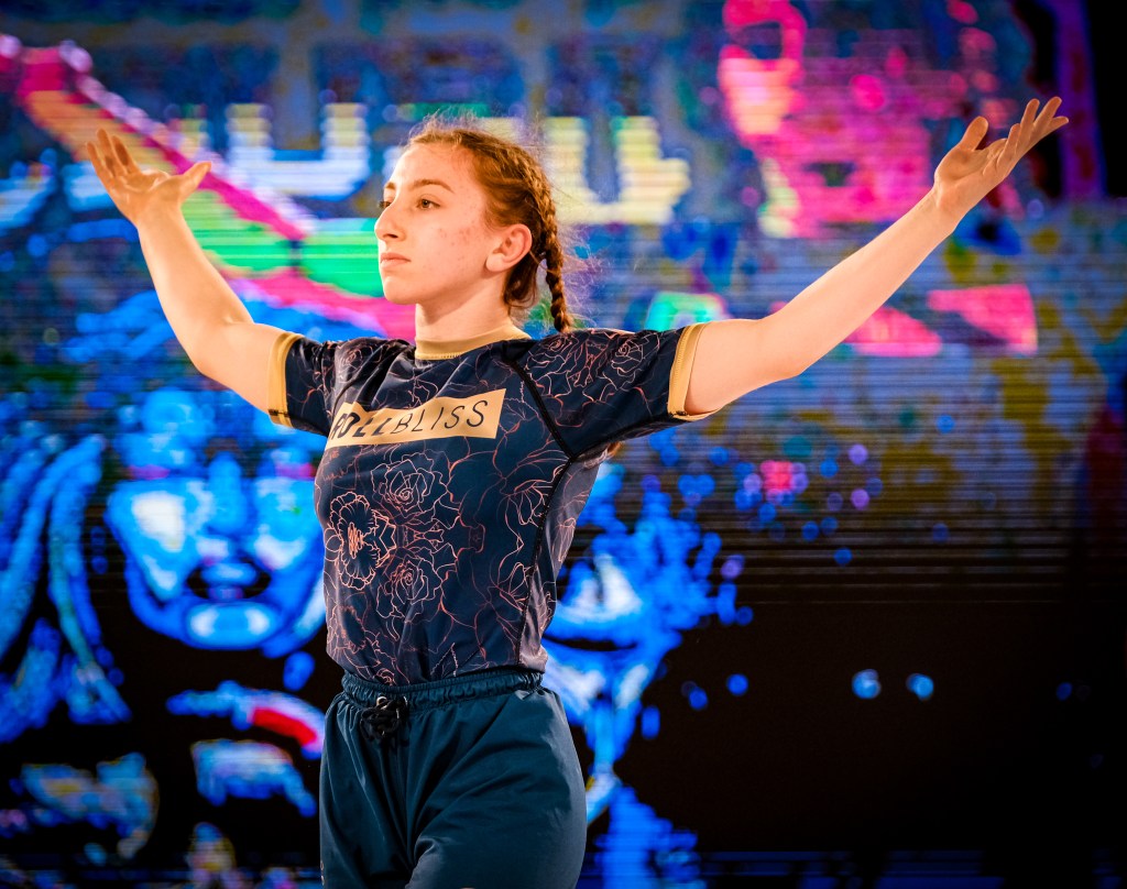 “Image of a girl with both of her arms raised up in the air in celebration of a triumphant victory”